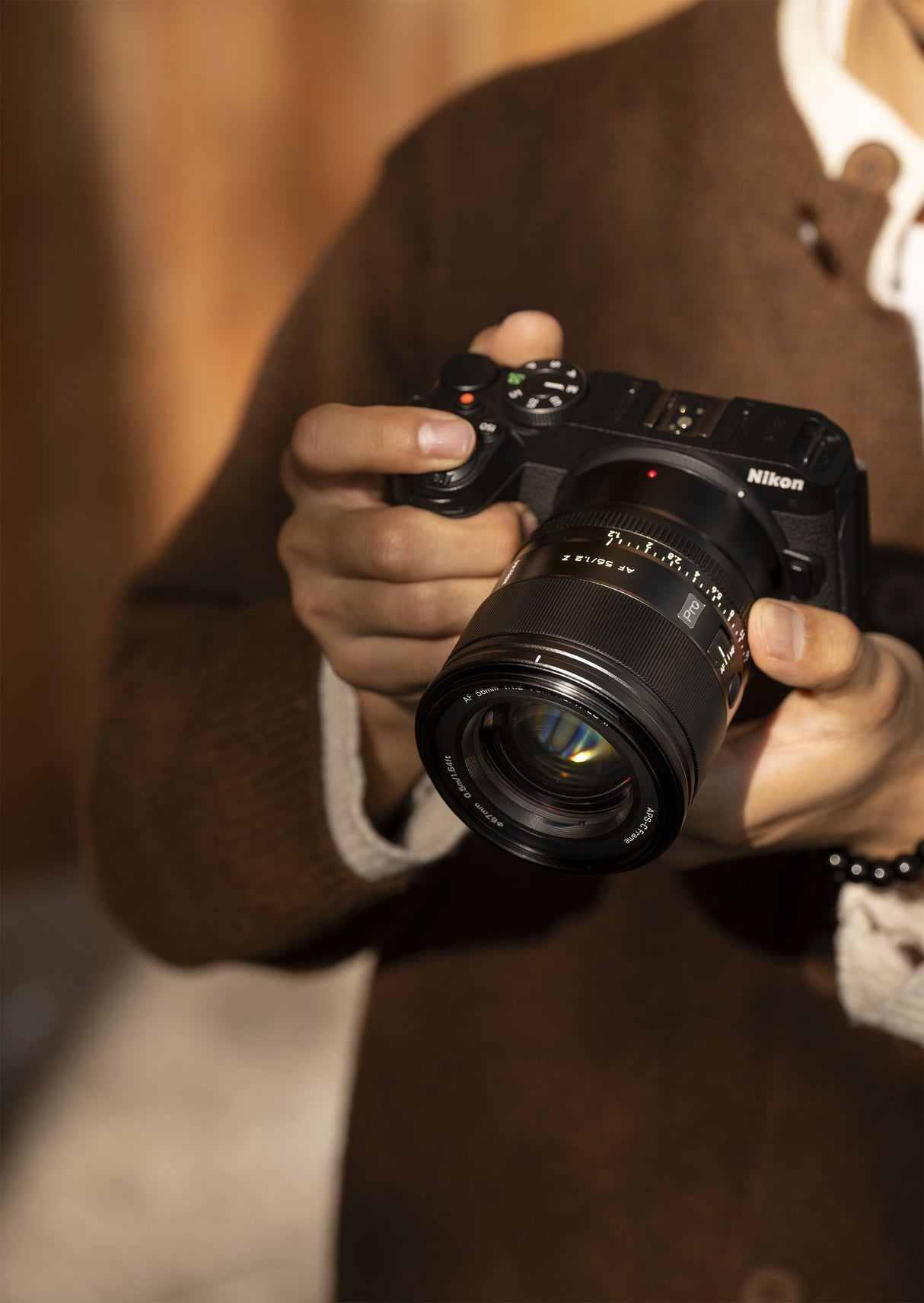 Kamera Nikon mit Viltrox Objektiv haltend